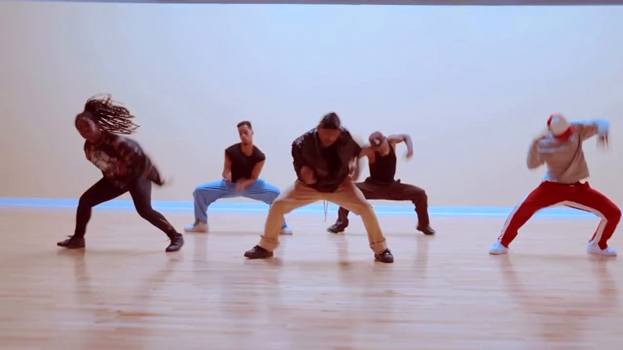 Dancers in a low stance during class