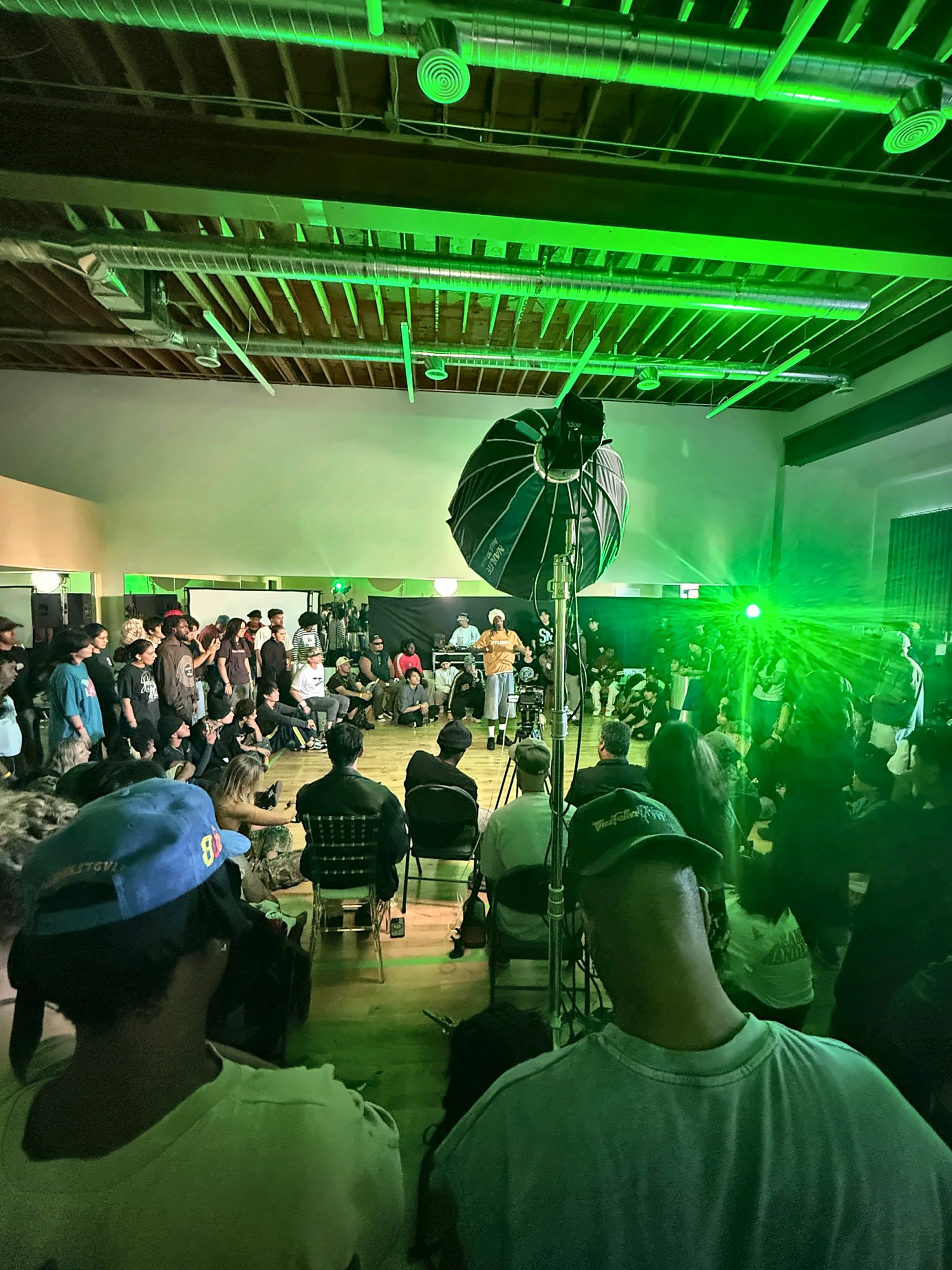 Crowd watching a dance battle under green lights