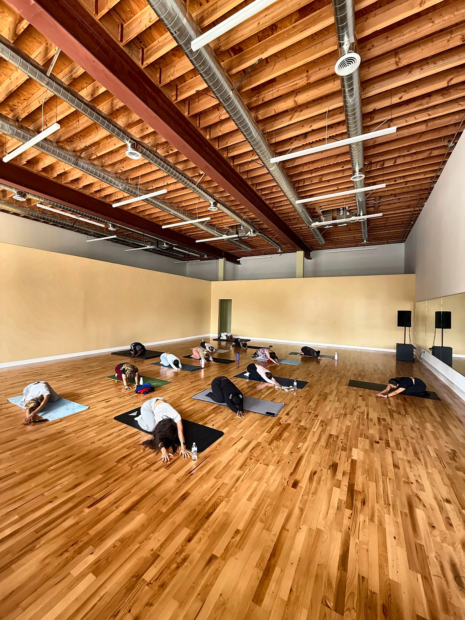 Students resting in child’s pose during a stretch class